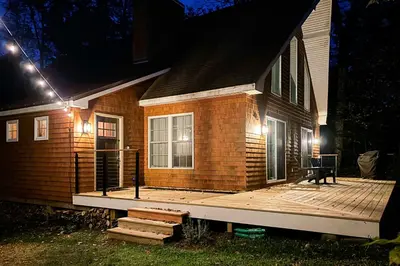 a house with a wooden deck at night at Buckboard Haven in Dover