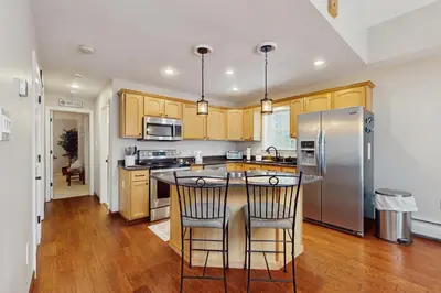 a kitchen with wooden cabinets and a stainless steel refrigerator at Buckboard Haven in Dover