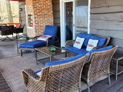 a patio with blue cushioned chairs and a table at Stunning Views from the Fire Tower Cabin in Cambridge