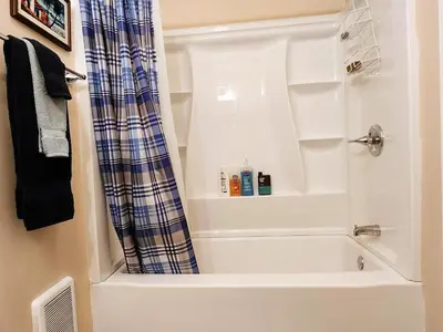 a bathroom with a bath tub with a shower curtain at Stunning Views from the Fire Tower Cabin in Cambridge