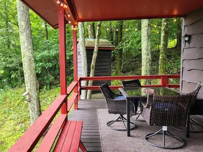 a deck with a table and chairs on a cabin at Stunning Views from the Fire Tower Cabin in Cambridge