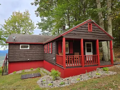 a red and black tiny house in the woods at Stunning Views from the Fire Tower Cabin in Cambridge