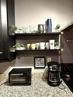 a kitchen counter with a shelf with pots and pans at Spacious 4BR Retreat Yard, BBQ & Prime Location in Clifton Park
