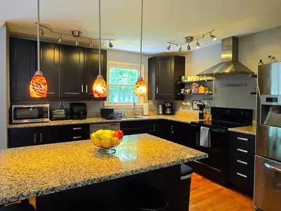a kitchen with a bowl of fruit on a counter at Spacious 4BR Retreat Yard, BBQ & Prime Location in Clifton Park