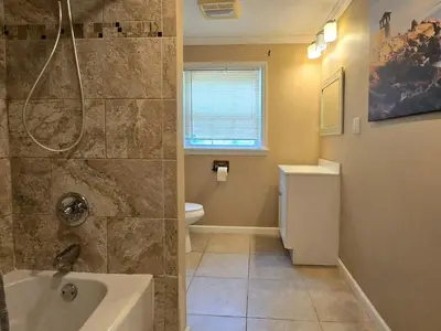 a bathroom with a shower and a sink and a toilet at Spacious 4BR Retreat Yard, BBQ & Prime Location in Clifton Park