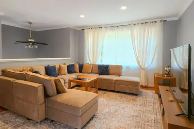 a living room with a couch and a tv at Spacious 4BR Retreat Yard, BBQ & Prime Location in Clifton Park