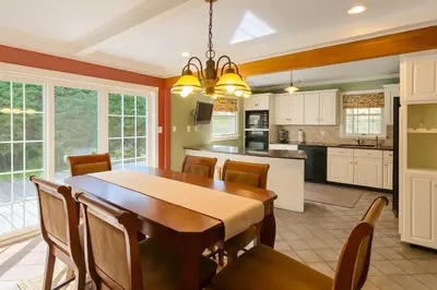 a kitchen and dining room with a wooden table and chairs at Large Villa 5 Beds, 3 Baths, Firepit, Cozy Stay in Fort Edward