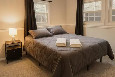 a bedroom with a bed with two towels on it at Best house in town in Latham