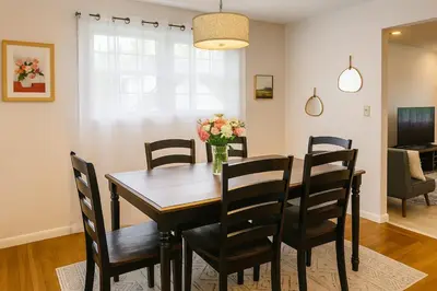 a dining room table with chairs and a vase of flowers at Best house in town in Latham