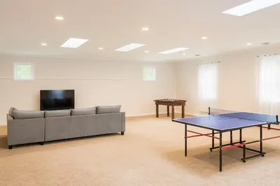 a living room with a couch and a table at Best house in town in Latham