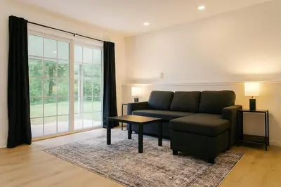 a living room with a couch and a table at Best house in town in Latham