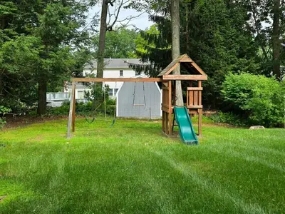 a playground with a slide in the middle of a yard at Best house in town in Latham