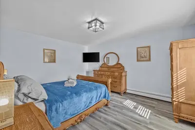 a bedroom with a bed and a dresser and a tv at Cozy Farmhouse - Fireplace, Backyard, BBQ, Games - 3 MIN TO CAMELBACK in Tannersville