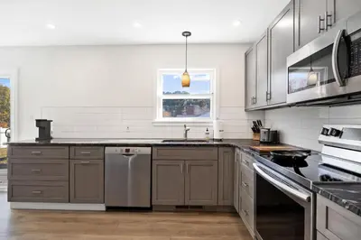 a kitchen with stainless steel appliances and a window at Pet-Friendly Saratoga Home with Fire Pit & Deck in Saratoga Springs