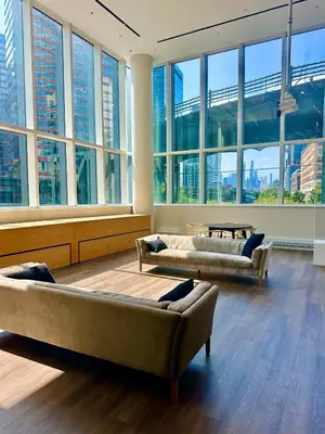 a large room with two couches and large windows at Elegant Long Island City Studio with Skyline Views in Roosevelt Island