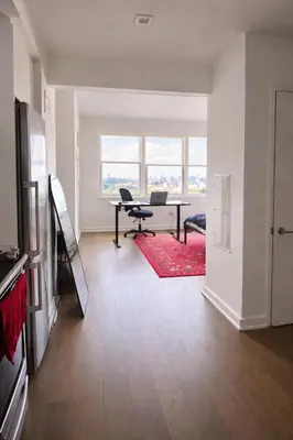 a living room with a table with a laptop on it at Elegant Long Island City Studio with Skyline Views in Roosevelt Island