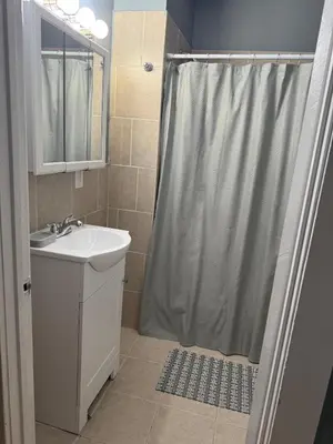 a bathroom with a sink and a shower with a shower curtain at Eagle Pamir Guest House in New Haven