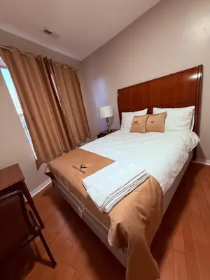 a bedroom with a large bed with a wooden headboard at Eagle Pamir Guest House in New Haven