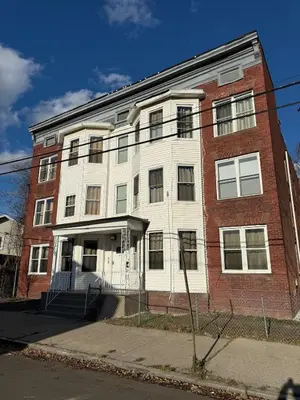 a large brick building on a city street at Eagle Pamir Guest House in New Haven