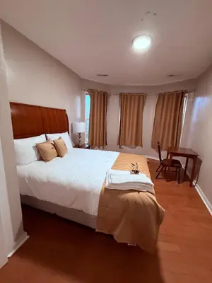 a bedroom with a large bed and a table at Eagle Pamir Guest House in New Haven