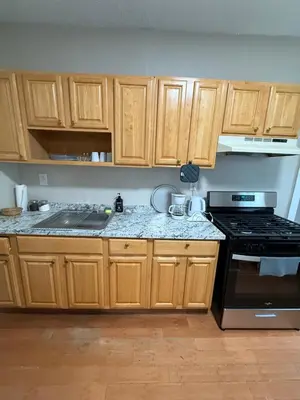a kitchen with wooden cabinets and a stove at Eagle Pamir Guest House in New Haven
