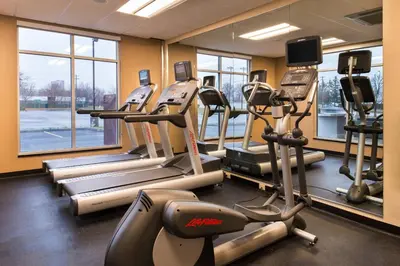 a gym with treadmills and elliptical machines at Fairfield Inn & Suites by Marriott Utica in Utica