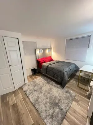 a bedroom with a bed with a red pillow and a rug at Home in West Haven