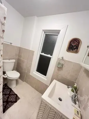 a bathroom with a toilet and a sink and a window at Home in West Haven