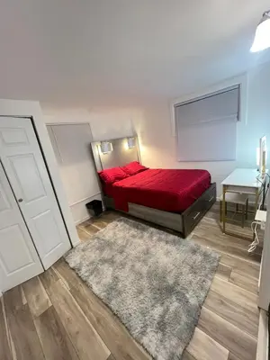 a bedroom with a red bed and a rug at Home in West Haven