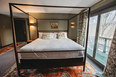a bedroom with a canopy bed and a large window at Hideaway Inn Mt Snow in Dover