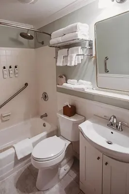 a white bathroom with a toilet and a sink at Hideaway Inn Mt Snow in Dover