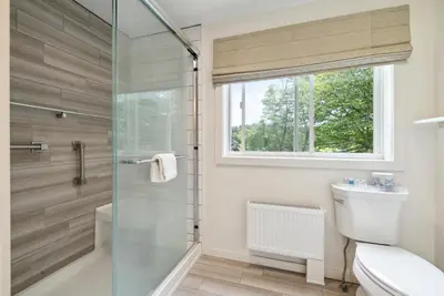 a bathroom with a shower and a toilet and a window at Hideaway Inn Mt Snow in Dover