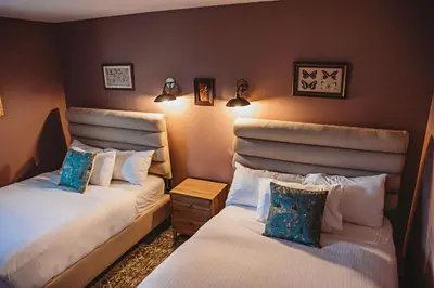 a room with two beds and two lamps on the wall at Hideaway Inn Mt Snow in Dover