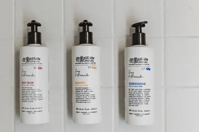three white shampoo bottles are lined up on a wall at Hideaway Inn Mt Snow in Dover