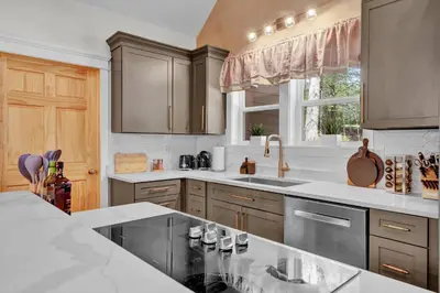 a kitchen with gray cabinets and a sink and a window at Golf Sim, Game-Movie Room, Spa, Sauna, Arcade ! in Tobyhanna