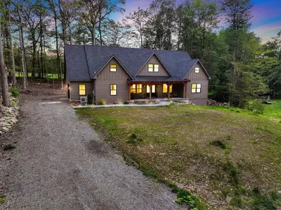 a large house with a gambrel roof on a field at Golf Sim, Game-Movie Room, Spa, Sauna, Arcade ! in Tobyhanna