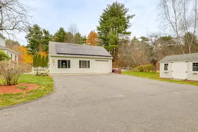 a house with a solar roof on a driveway at Hike and Explore Western Mass Peaceful Studio in Palmer