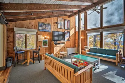 a living room with a couch and a table at 8 Mi to Mt Snow Cozy Bear Cabin with Hot Tub! in Wilmington
