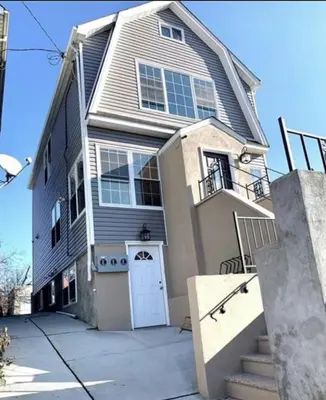 a large house with a white door on a street at Brand New House in Bronx