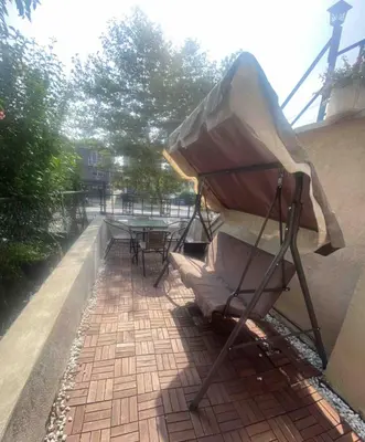 a patio with a table and a umbrella on a sidewalk at Brand New House in Bronx