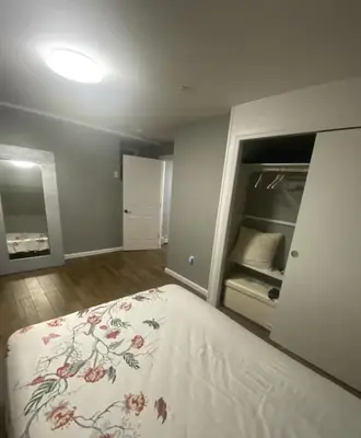 a bedroom with a bed with a floral bedspread at Brand New House in Bronx