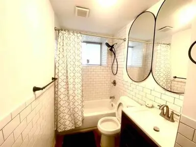 a bathroom with a sink and a toilet and a mirror at Brand New House in Bronx