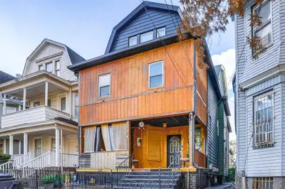 a wooden house with a black roof at Upper Clinton Hill Studio! Walk to Eats and Shops in Newark
