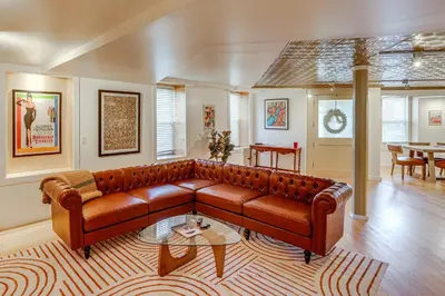 a living room with a brown leather couch at Walk to Athens Riverfront Park! Modern-Retro Apt in Athens