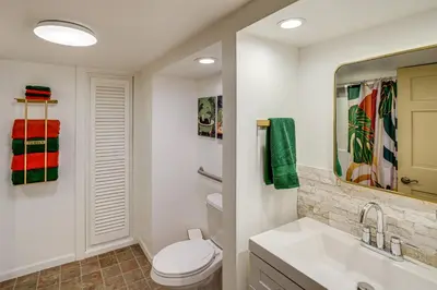 a bathroom with a toilet and a sink and a mirror at Walk to Athens Riverfront Park! Modern-Retro Apt in Athens