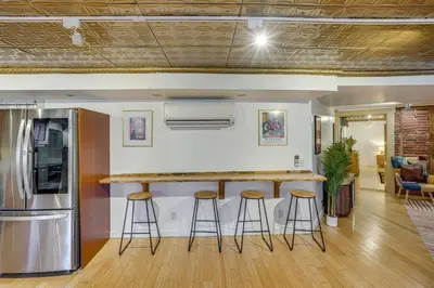 a kitchen with a counter and stools in a room at Walk to Athens Riverfront Park! Modern-Retro Apt in Athens