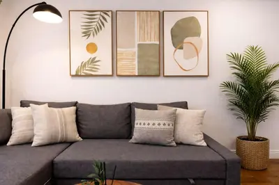 a living room with a gray couch and some paintings at Hip NYC Hideaway in Lively East Village in New York