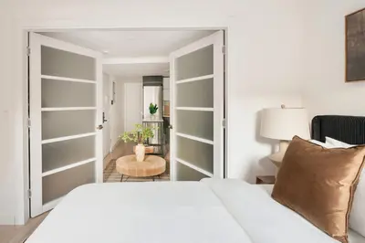 a bedroom with a white bed and a room with a table at 22nd Sleek Modern 1BR Gramercy in New York