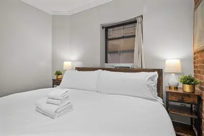a bedroom with a white bed with towels on it at Sleek Midtown East Stay Near Everything in New York