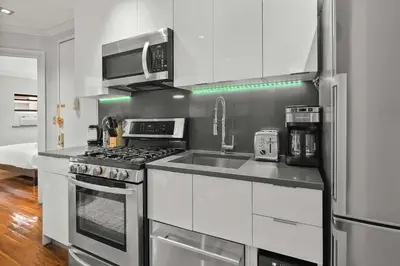 a kitchen with a stove and a sink and a microwave at Sleek Midtown East Stay Near Everything in New York